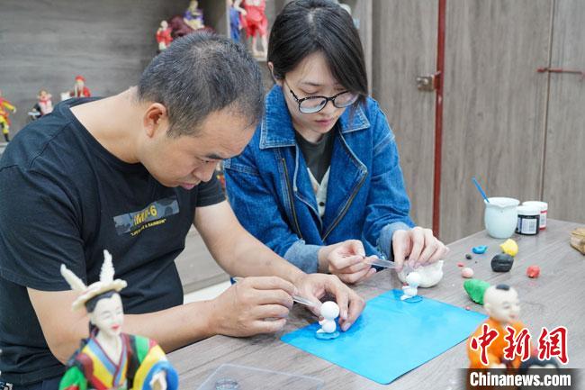 <a target='_blank'  data-cke-saved- >中新社</a>記者(右)現(xiàn)場體驗(yàn)面塑制作過程?！￡悹帍?qiáng) 攝