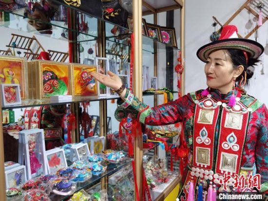 圖為身著民族服飾的隴原巧手展示手工藝品。(資料圖) 徐雪 攝