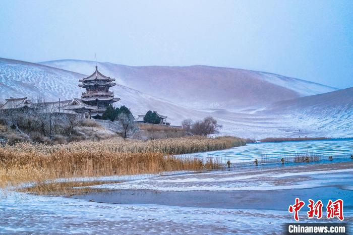 2021年11月28日，雪落鳴沙山月牙泉景區(qū)?！⊥醣筱y 攝