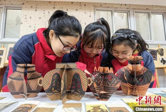 圖為學生用紙創(chuàng)作的立體彩陶?！⒂裉?攝