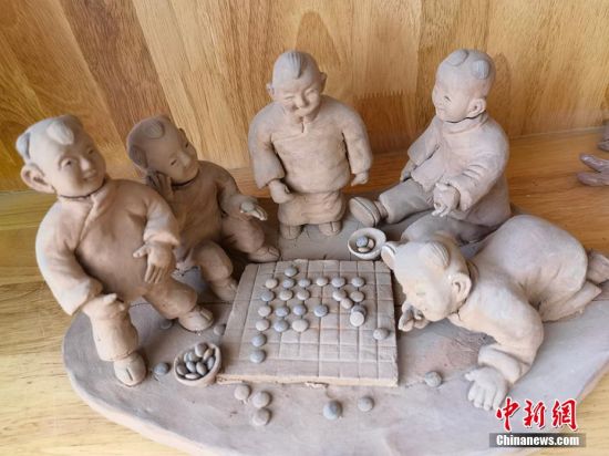 圖為泥塑作品展現(xiàn)下棋場(chǎng)景。 劉玉桃 攝