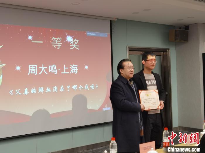 圖為作家、西北師范大學新聞與傳媒學院院長徐兆壽頒發(fā)一等獎證書，代領獎者上臺領獎。　楊娜 攝