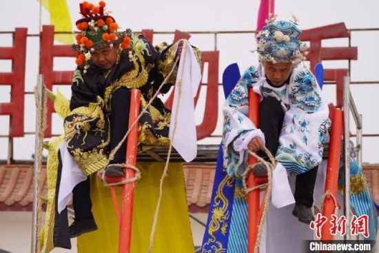 圖為“苦水高高蹺”表演者通過(guò)麻繩將腳固定在腳踏板，并在腿部纏繞六七圈?！【琶赖┰?攝