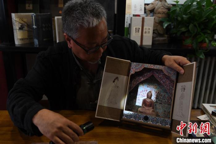 圖為讀者出版集團讀者晉林工作室獨立出品人徐晉林，展示互動性強的敦煌題材手工書。(資料圖) 楊艷敏 攝