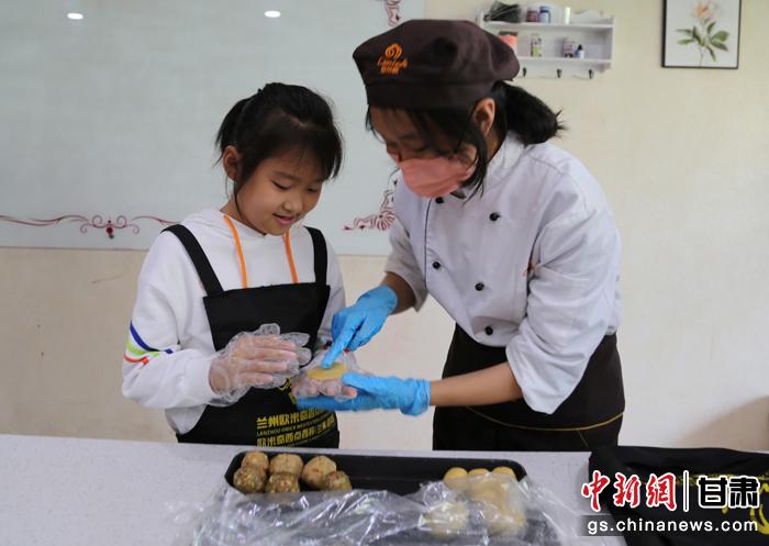 圖為在甘臺胞小朋友在工作人員指導(dǎo)下制作月餅。九美旦增 攝
