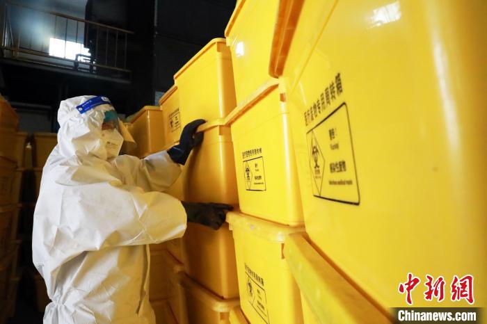 圖為工作人員搬運醫(yī)療廢物專用周轉(zhuǎn)箱。　魏建軍 攝