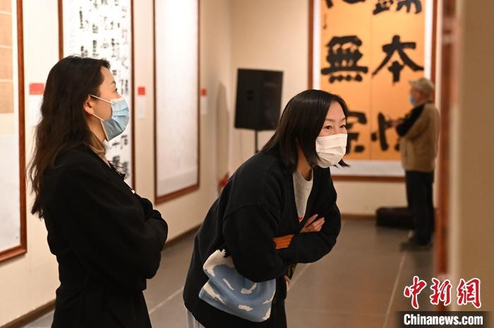 圖為甘肅蘭州，參展書(shū)法作品吸引參觀者。 中新社記者 李亞龍 攝