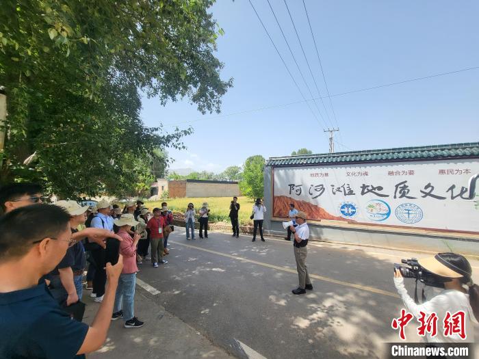 圖為中國地質(zhì)大學(xué)(北京)教授張緒教介紹村落情況。　胡友軍 攝