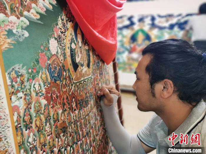 圖為更登才讓的徒弟繪畫唐卡?！?zhí)砀?攝
