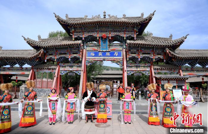 圖為身穿土族服飾的工作人員迎接訪客?！⊙Φ?攝