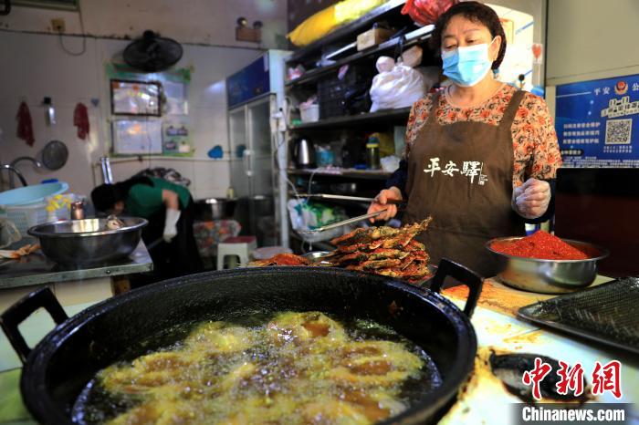 圖為平安驛·河湟民俗文化體驗(yàn)地內(nèi)的商戶炸干板魚(yú)?！⊙Φ?攝