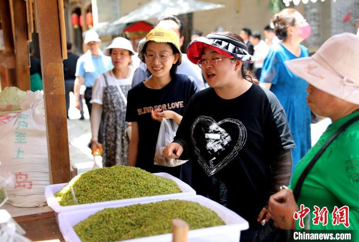 圖為民眾購(gòu)買(mǎi)青海特色小吃?！⊙Φ?攝