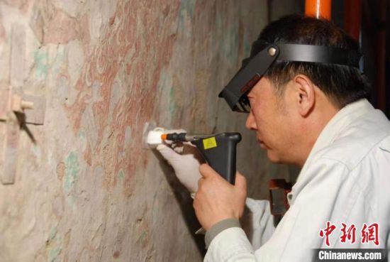 敦煌研究院研究員樊再軒進(jìn)行壁畫(huà)修復(fù)。(資料圖)張?jiān)莆?攝