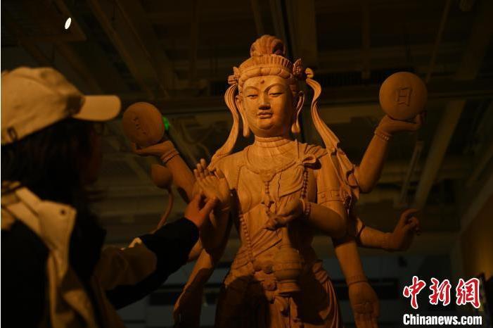 圖為季茂杰觀察自己創(chuàng)作的敦煌木雕。李亞龍 攝</p>
<p>