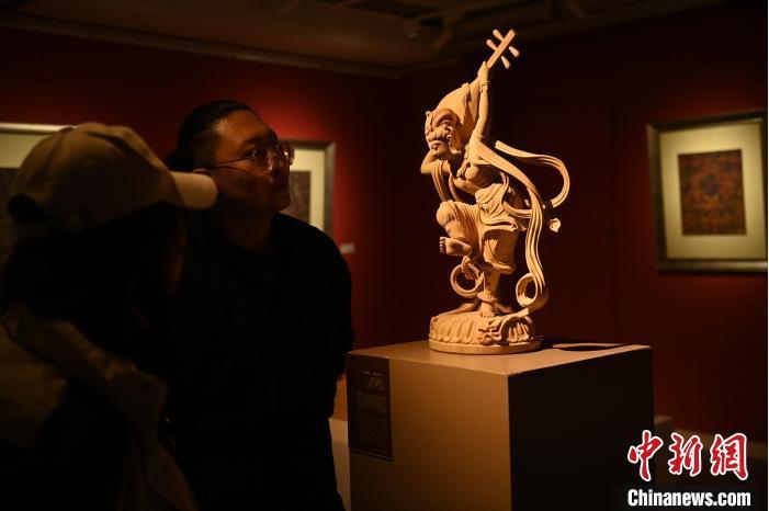 圖為季茂杰向參觀者介紹自己創(chuàng)作敦煌木雕的過(guò)程。李亞龍 攝</p>
<p>