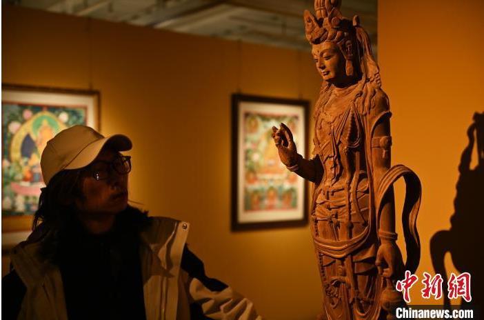 圖為季茂杰觀察自己創(chuàng)作的敦煌木雕。李亞龍 攝</p>
<p>