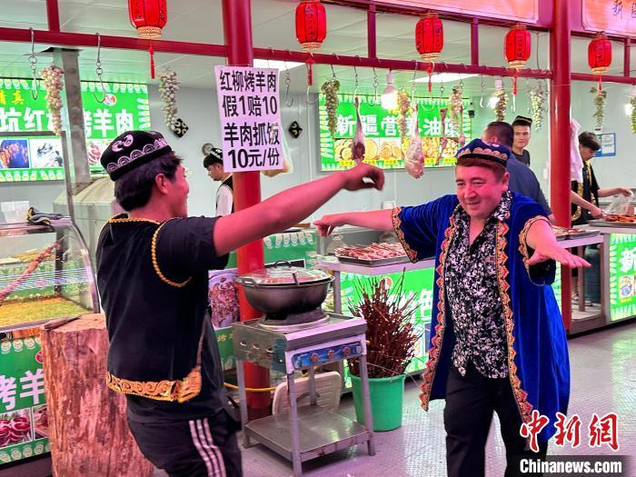 圖為餐飲經(jīng)營者在“西涼不夜城”跳起舞蹈引客?！〈魑牟?攝</p><p>