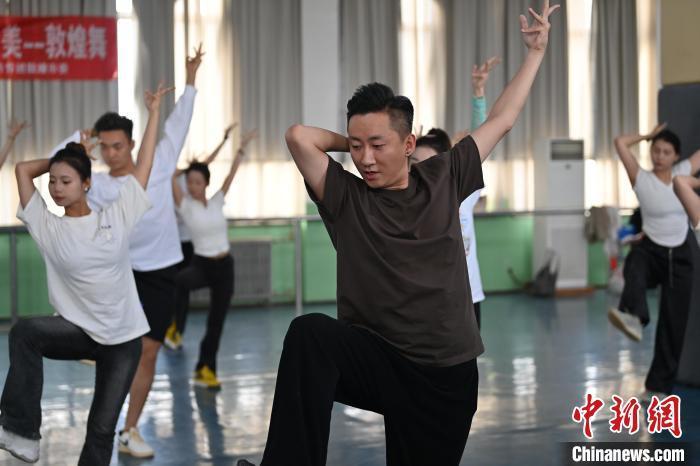 6月6日，在甘肅敦煌青年夜校課程中，青年學(xué)員學(xué)習(xí)敦煌舞課程。李亞龍 攝　　