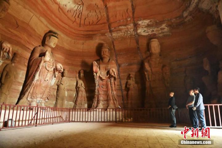 7月15日，游人參觀甘肅省平?jīng)鍪袥艽h百里石窟長廊中的南石窟寺1號窟。百里石窟長廊位于涇川縣境內(nèi)，由512個石窟、5眼窟中石井組成，現(xiàn)存王母宮石窟、鳳凰山石窟、南石窟寺、丈八寺石窟、羅漢洞石窟、太山寺石窟等規(guī)模較大的石窟群，還有數(shù)量眾多的小石窟群。南石窟寺開鑿于北魏永平三年，其中1號窟屬于大型七佛窟，七佛高達6米。中新社記者 李亞龍 攝