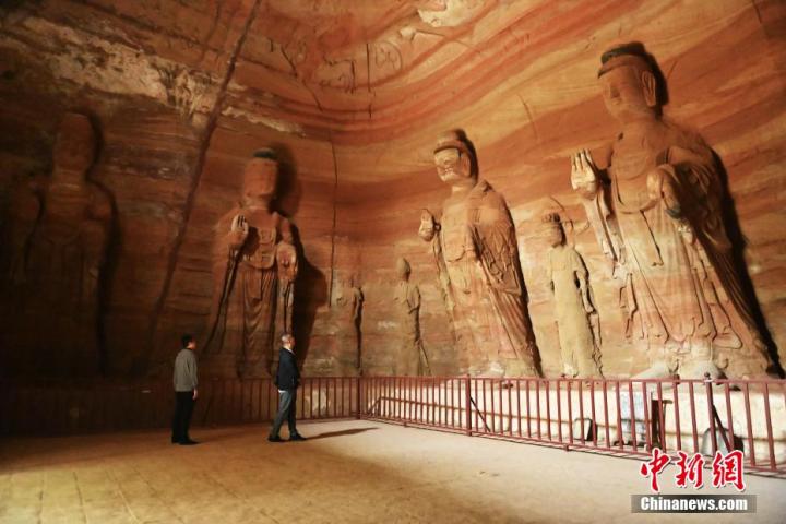 7月15日，游人參觀甘肅省平?jīng)鍪袥艽h百里石窟長廊中的南石窟寺1號窟。百里石窟長廊位于涇川縣境內(nèi)，由512個石窟、5眼窟中石井組成，現(xiàn)存王母宮石窟、鳳凰山石窟、南石窟寺、丈八寺石窟、羅漢洞石窟、太山寺石窟等規(guī)模較大的石窟群，還有數(shù)量眾多的小石窟群。南石窟寺開鑿于北魏永平三年，其中1號窟屬于大型七佛窟，七佛高達6米。中新社記者 李亞龍 攝