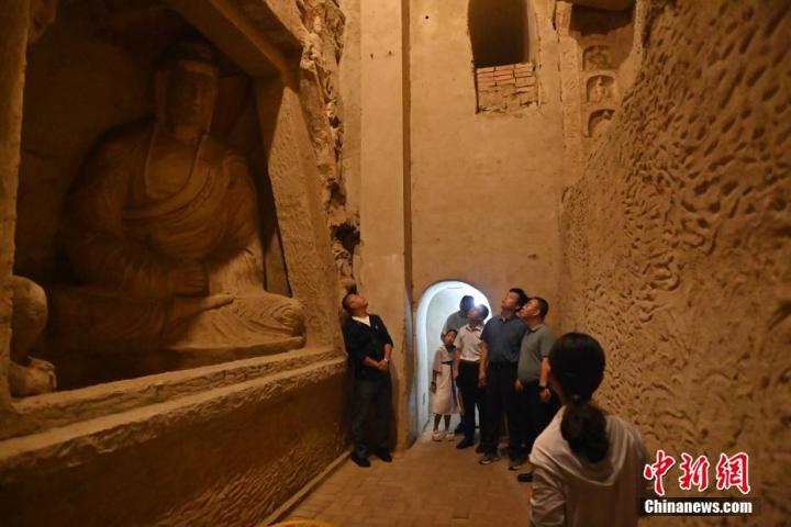 7月15日，游人參觀甘肅省平?jīng)鍪袥艽h百里石窟長廊中的王母宮石窟。百里石窟長廊位于涇川縣境內(nèi)，由512個石窟、5眼窟中石井組成，現(xiàn)存王母宮石窟、鳳凰山石窟、南石窟寺、丈八寺石窟、羅漢洞石窟、太山寺石窟等規(guī)模較大的石窟群，還有數(shù)量眾多的小石窟群。王母宮石窟又名千佛洞，該窟設(shè)計宏大，造像生動，窟內(nèi)擁有造像數(shù)百尊，是較為珍貴的佛教文化歷史遺存。中新社記者 李亞龍 攝</p>
<p>