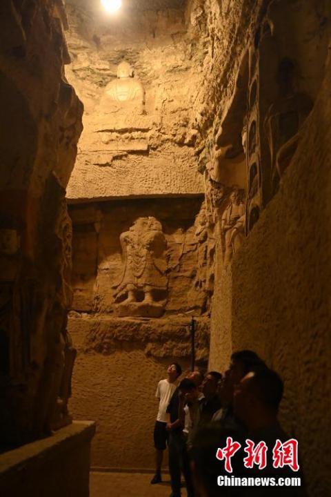 7月15日，游人參觀甘肅省平?jīng)鍪袥艽h百里石窟長廊中的王母宮石窟。百里石窟長廊位于涇川縣境內(nèi)，由512個石窟、5眼窟中石井組成，現(xiàn)存王母宮石窟、鳳凰山石窟、南石窟寺、丈八寺石窟、羅漢洞石窟、太山寺石窟等規(guī)模較大的石窟群，還有數(shù)量眾多的小石窟群。王母宮石窟又名千佛洞，該窟設(shè)計宏大，造像生動，窟內(nèi)擁有造像數(shù)百尊，是較為珍貴的佛教文化遺存。中新社記者 李亞龍 攝</p>
<p>