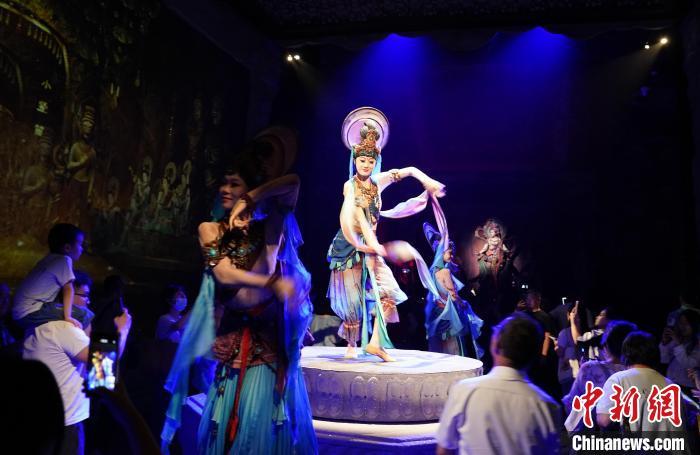 《樂動敦煌》是全球首部洞窟式沉浸體驗劇，利用真人與數(shù)字影像虛實交換實現(xiàn)沉浸式體驗。圖為2023年8月28日晚，《樂動敦煌》演出。(資料圖)中新社記者 毛建軍 攝