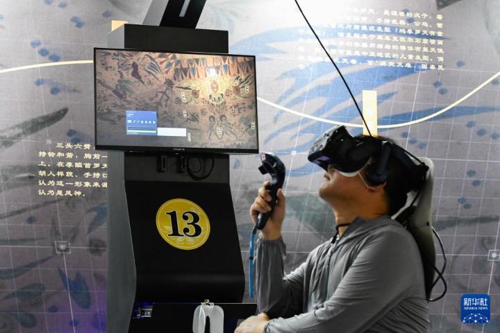 7月22日，游客借助VR設備沉浸式游覽莫高窟第285窟虛擬場景。新華社記者 郎兵兵 攝